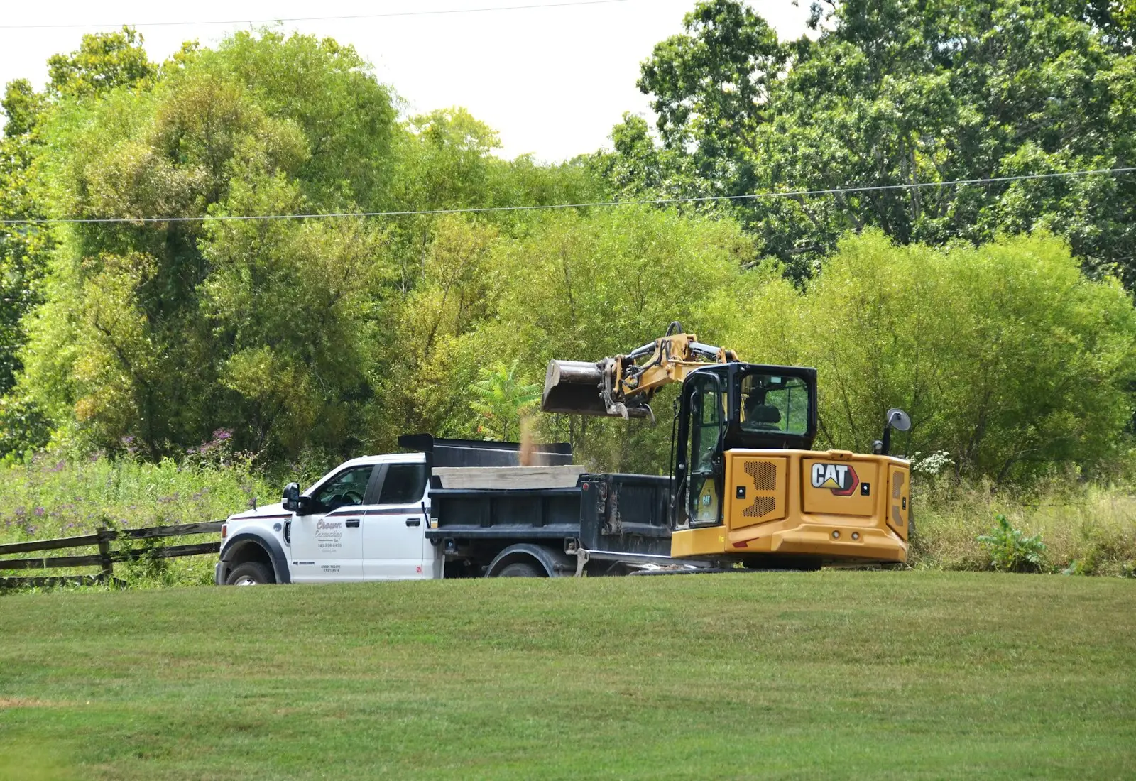 Mini excavator loading soil into a truck