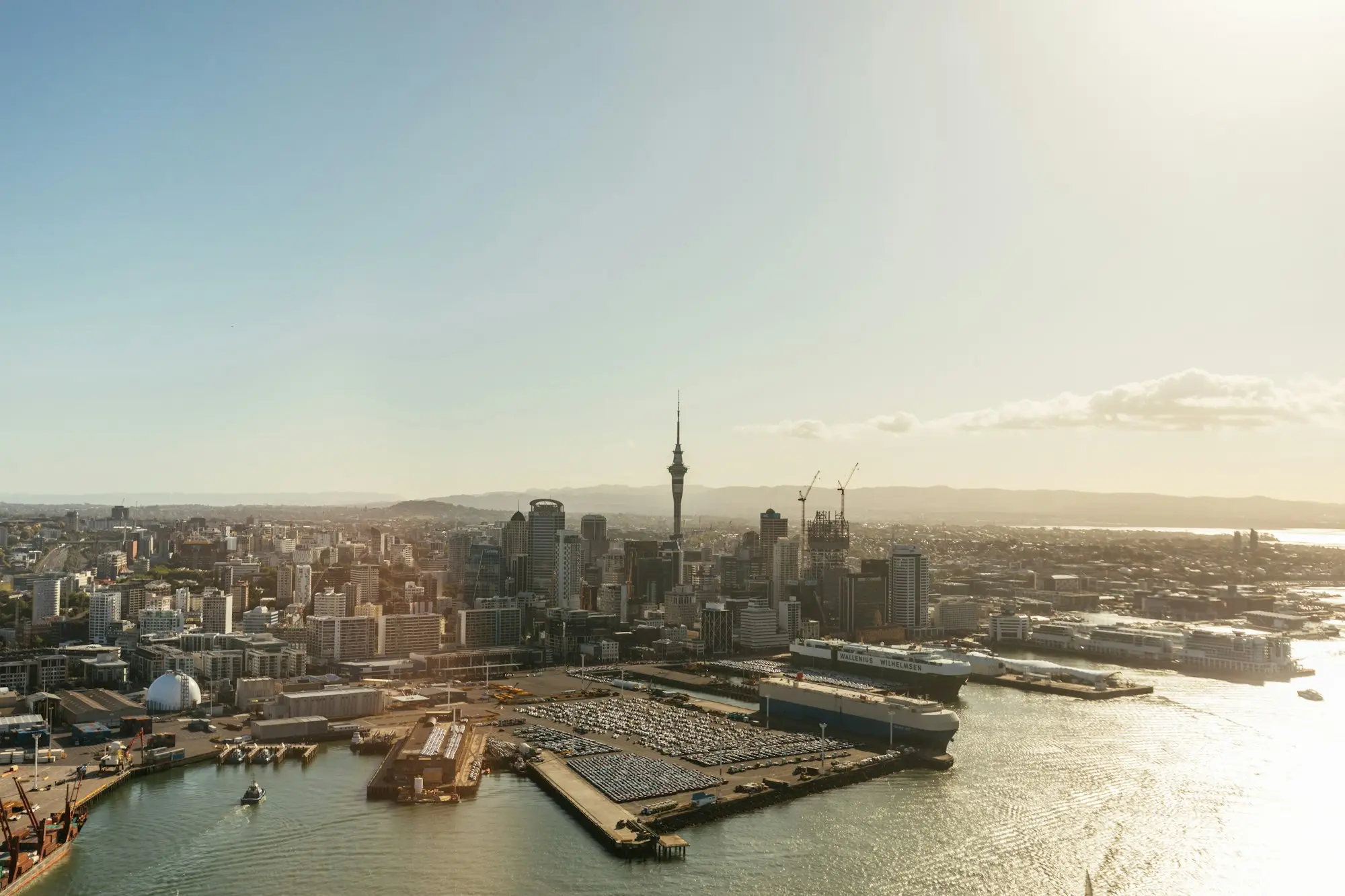 Auckland CBD apartment towers and the Sky Tower beside the Waitematā Harbour waterfront